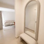 Moderan apartman sa pogledom na bazen sa elegantnim ulaznim hodnikom, ogledalom i modernim enterijerom.