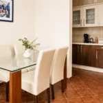 Moderan apartman sa pogledom na bazen sa trpezarijskim stolom i potpuno opremljenom kuhinjom.