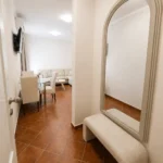 Moderan apartman sa pogledom na bazen sa elegantnim ulaznim prostorom, ogledalom i pristupom dnevnom boravku.